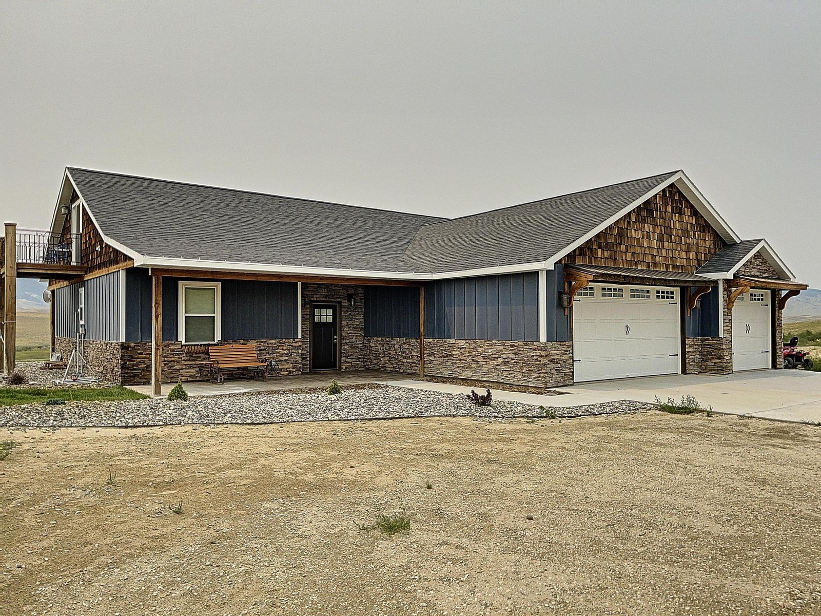A custom stone-and-timber ranch home built by Greenhouse Construction under a wide Wyoming sky